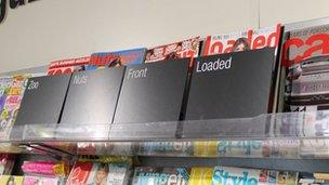 Lads' mags concealed on a supermarket shelf.