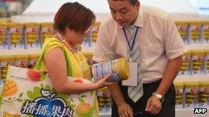 Woman looks at milk at a trade show in Shanghai