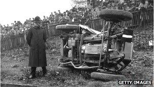 6th April 1931: A policeman stands by a wrecked 4.5 litre Invicta lying on its side after overturning during a race at Brooklands