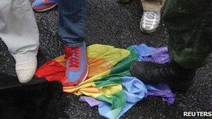 Anti-gay rights activists in Moscow stand on a rainbow flag during a protest by activists demonstrating against a proposed new law. Picture dated 11/06/2013