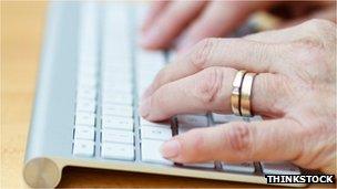 An old lady's hands on a computer keyboard