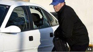 A thief breaks into a car during a mock-up by the Police Service of Northern Ireland in Belfast, Monday November 21, 2005.