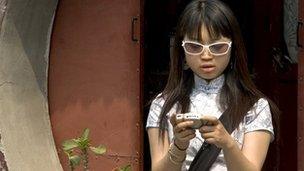 Young Chinese woman using her mobile phone