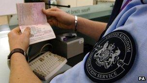 United Kingdom Immigration officer checking a passport at Heathrow Airport