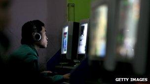 Young Chinese man in an internet cafe