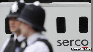 Officers stand in front of a prison van