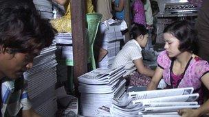 People folding printed newspapers