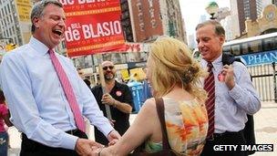 Democratic mayoral candidate Bill de Blasio (L) and former Vermont Gov. Howard Dean (R) greet commuters at a subway station on 27 August 2013