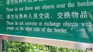 A sign along the Chinese border warns against interacting with North Koreans