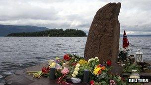 Flowers and candles are placed on the shore opposite to the Utoeya Island, Norway, Sunday, 24 July, 2011