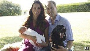 The Duke and Duchess of Cambridge sitting in a garden with their baby, Prince George, and two dogs