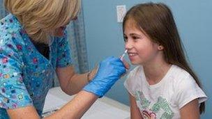 Girl being given flu vaccine nasally