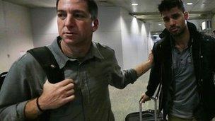 Glenn Greenwald (left) and his partner David Miranda (right) were reunited when Mr Miranda arrived back in Brazil