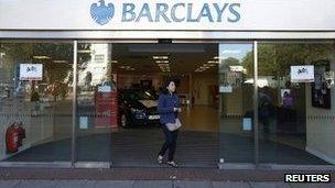 A woman leaves the Swiss Cottage branch of Barclays in north London