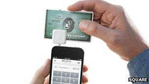 Square card reader plugged into mobile phone