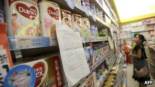 A Chinese consumer looking at baby milk formula in a store in China