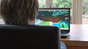 Boy plays Minecraft at kitchen table