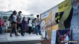 Women walk past an anti-Iran protest in Washington