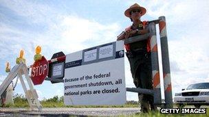 A park ranger stands by the gate of a closed national park in Miami, Florida.