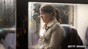 A picture of a woman on a bus in the rain