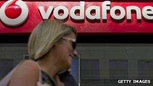 Woman walks past Vodafone shop