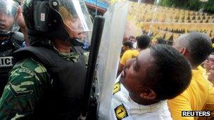 A supporter of Mohamed Nasheed shouts slogans in front of a police officer during a protest in Male on 27 September