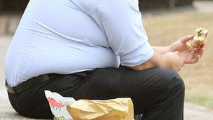 Obese man eating burger