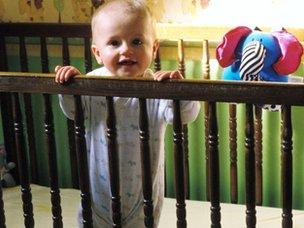 Baby standing in cot