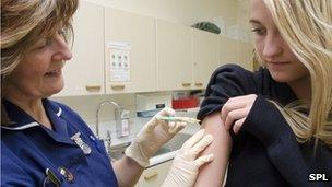 Nurses vaccinating a girl with the HPV jab