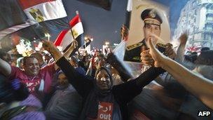 Crowd celebrates in Cairo's Tahrir Square with Egyptian flags and a sign of General Abdul Fattah al-Sisi on 3 July