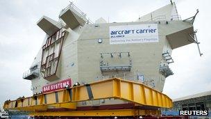 The aft island of the Royal Navy"s Queen Elizabeth class aircraft carrier is loaded onto a sea-going barge in Scotstoun