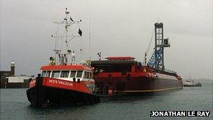 Mobile crane on barge entering Guernsey's St Peter Port Harbour