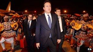 Prime Minister David Cameron is welcomed by traditional Sri Lankan dancers as he arrives in Colombo