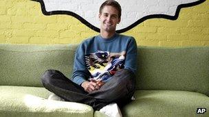 Evan Spiegel sits under the Snapchat logo