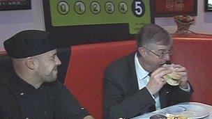 Mark Drakeford (right) marked the new law by a visit to a diner in Cardiff