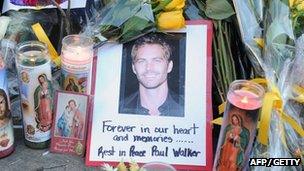 A photo of Fast & Furious actor Paul Walker is seen among flowers and candles left by fans at the site of the car accident in which he died north of California