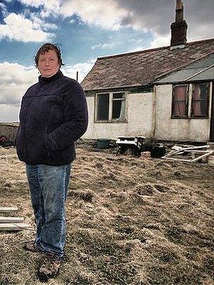 Bryony Nierop-Reading stands on the cliff edge next to her Happisburgh home