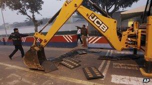 Indian police remove barricades that had been erected as a safety measure outside the main entrance of US Embassy 17 December 2013