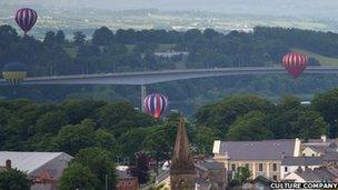 The balloons float past the Foyle Bridge