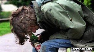 Person with drink on a park bench