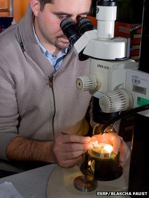 Scientist at ESRF loading a speck-sized magma rock sample into the anvils of a press.