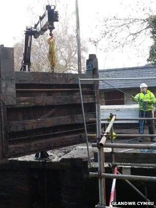 worker replacing a canal lock gate