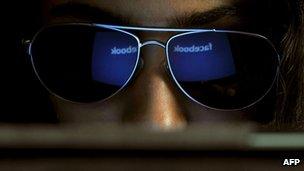 The Facebook logo is reflected in a young Indian woman's sunglasses