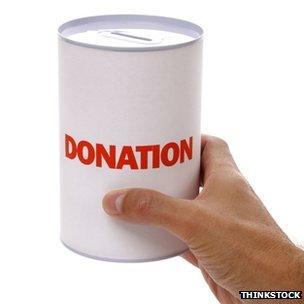 Hand holding a donation tin