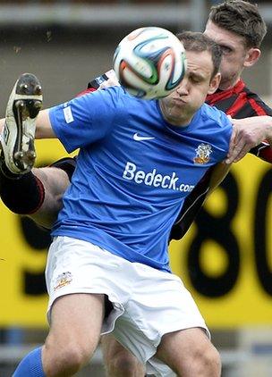 Glenavon striker Guy Bates shields the ball from Paul Leeman