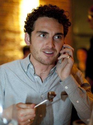 Man eating and listening to different sounds on his phone