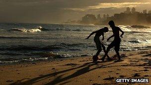 Boys play football on the beach in Salvador, Brazil