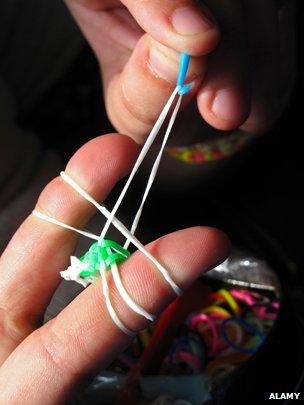 Child making a loom band