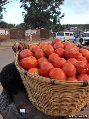 Market vendor carrying basket of fruit (Getty Images)