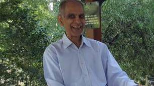 Bhim Kohli wearing a light-coloured shirt with trees in the background